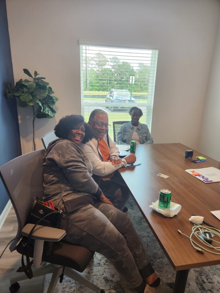 Three people sitting around a table.,