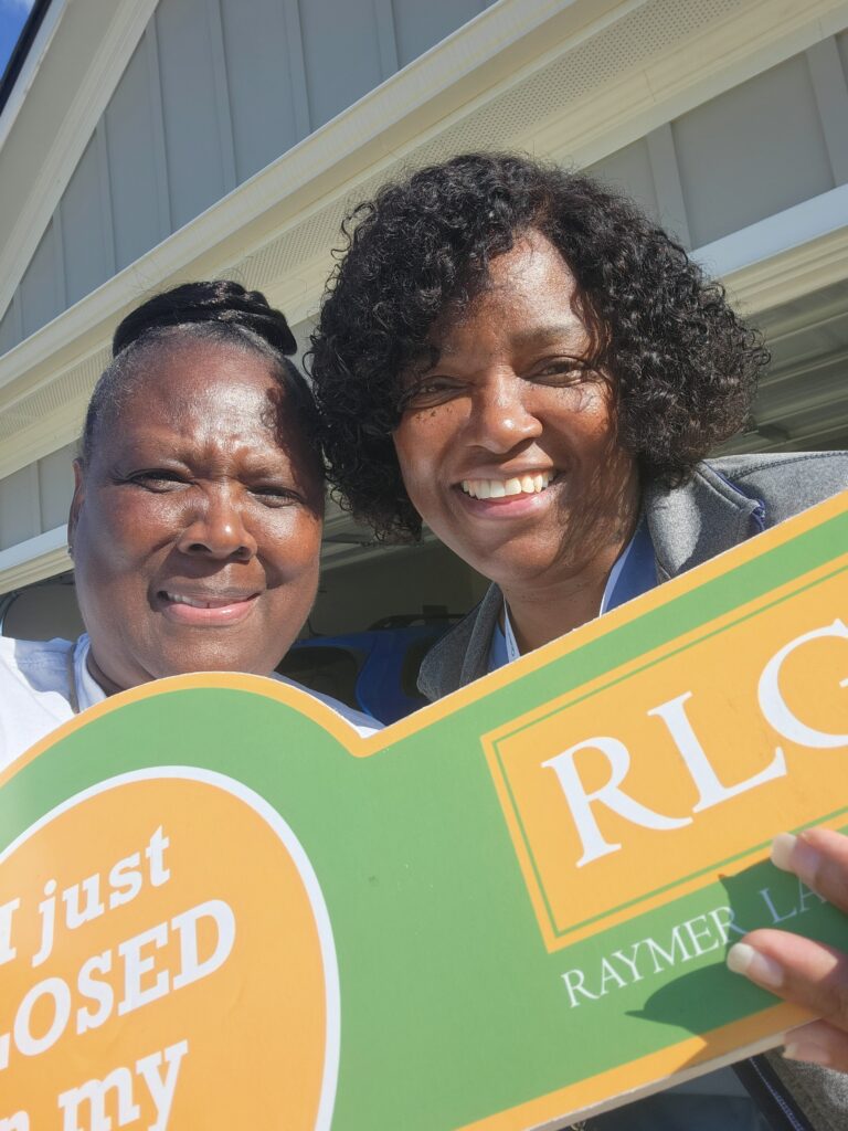 Two women holding a large key reading I just closed.