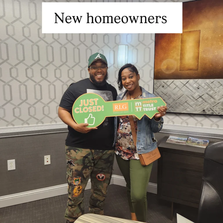 A young couple holding a large key reading I just closed.